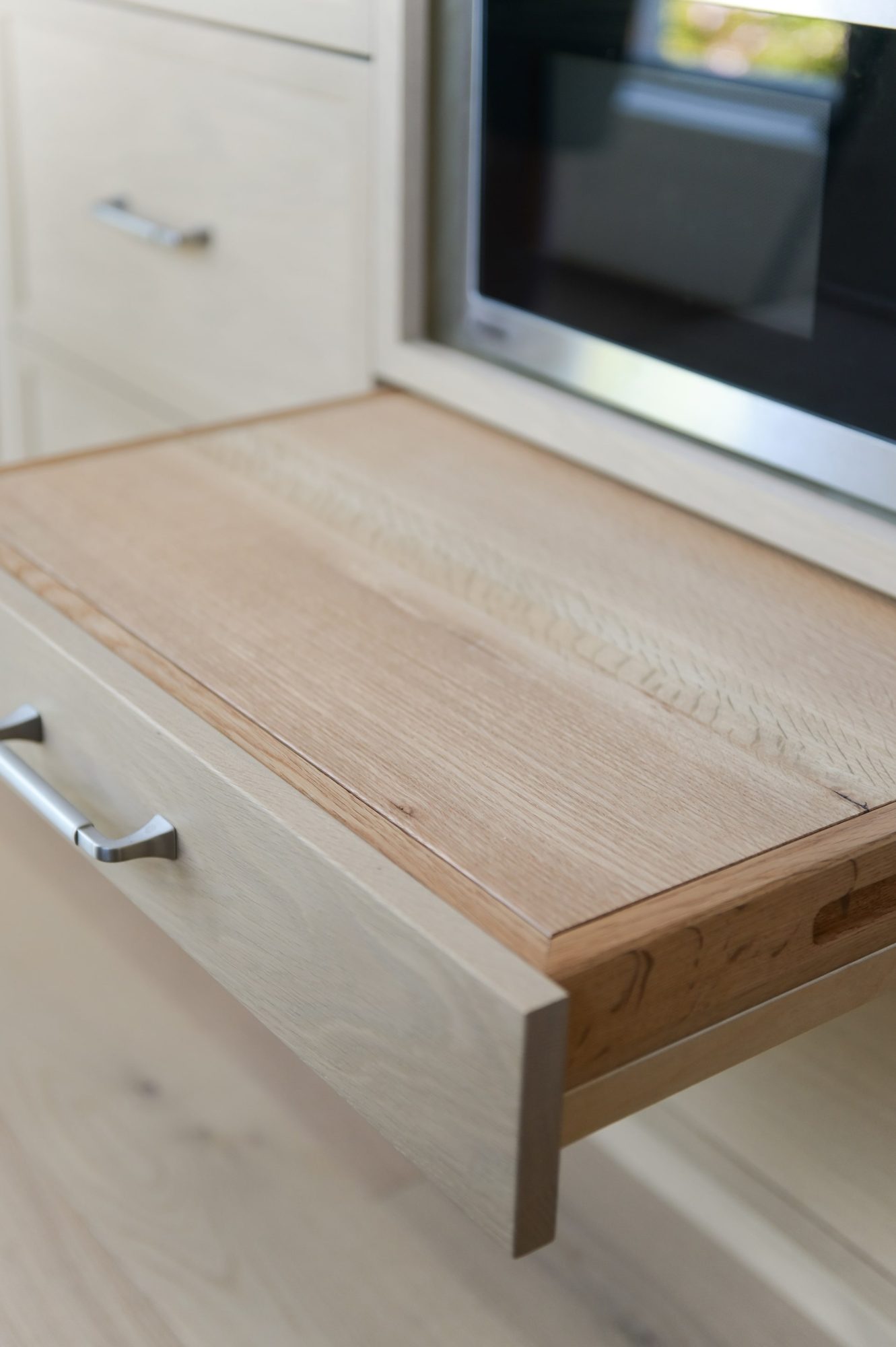 Close-up of custom natural wood cabinetry with built-in appliance drawer by Alderidge Construction, highlighting premium craftsmanship and hardware detail