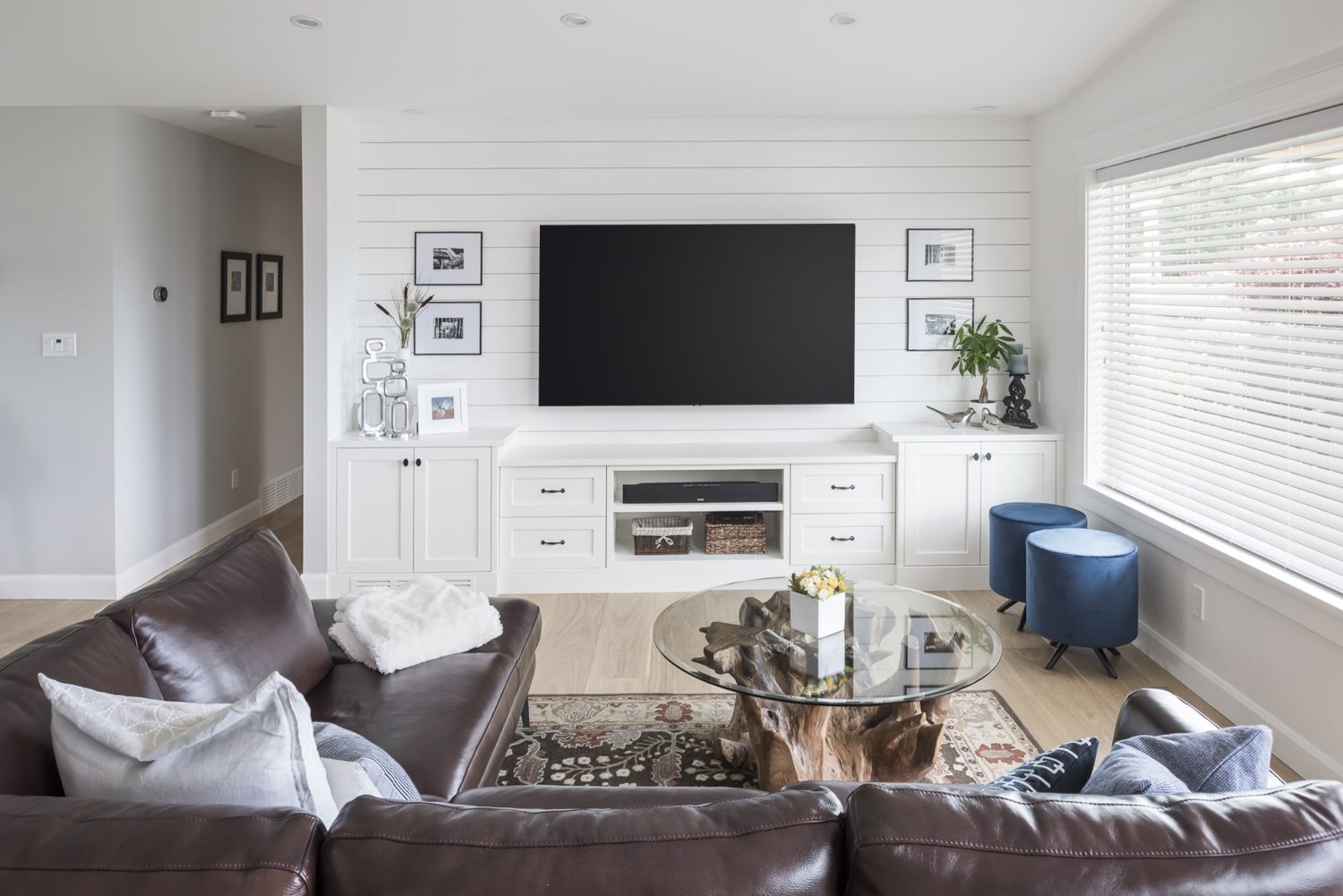 Custom built-in entertainment center with white cabinetry by Alderidge Construction, featuring shiplap accent wall and media storage in a modern living room